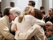 Afetados por incêndio florestal na região de Palisades, na Califórnia, EUA, se abraçam em missa especial na igreja Corpus Christi, destruída pelas chamas em Santa Monica, Los Angeles, EUA, em 12 de janeiro de 2025.