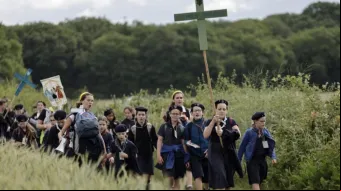 Jovens seguram cruzes ao chegarem para a missa na tradicional peregrinação de Pentecostes de Paris a Chartres, em Sonchamp, perto de Paris, no último domingo (8).